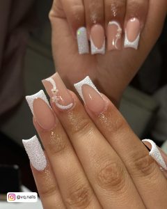 Ombre White Glitter Nails With Floral Designing Infront Of A Unclear Grey Background