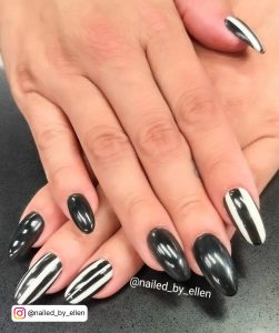 Oval Black And White Stripe Nails With Glossy Black Nails On Black Surface
