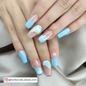 Pastel Blue And White Nails With Gold Accent Over White Clothe