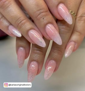 Pink And White Ombre Almond Nails With Glitter Over White Surface