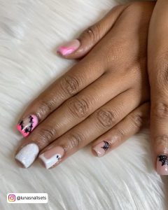 Pink And White Ombre Nails With Glitter On The Index Finger Are Placed Over Sleek White Fur.