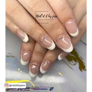 Round Short White Tip Acrylic Nails With Rhinestones Over Marble Surface