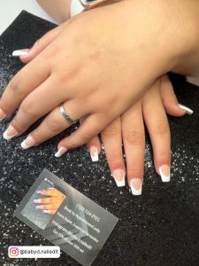 Round White Tip Nails On Shimmery Black Surface