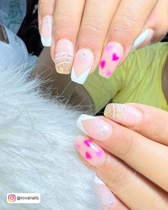 Shimmery V Tip White Gel Nails With Pink Heart, Gold Glitters, And Stones Over White Fur