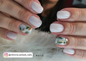 Short Milky White Nails With Blue And Green Leaf Design On The Feature Nail