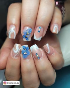 Short Pretty Acrylic Blue And White Nails With Flowery Rhinestones, Blue Stones, Line Work, And French Tips