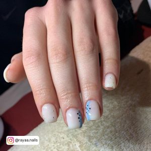 Short Square Tip Milky White Nails With A Light Blue Stripe With Black Dots On Two Feature Nails