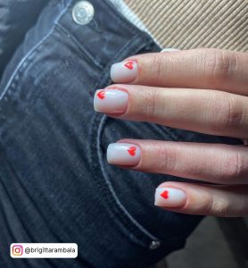 Short Square Tip Milky White Nails With A Small Red Heart On Each Nail