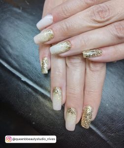 Short Square White And Gold Ombré Nails Over Black Surface