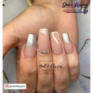 Silver And White Ombre Acrylic Nails With White Tips And Rhinestones Over White Surface