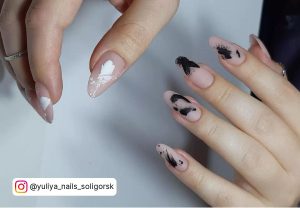 Simple Black And White Abstract Nail Art On Nude Base Over A White Surface.