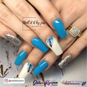 Simple Blue And White Acrylic Nails With Glitter And Leaf Design Over Artsy White Surface