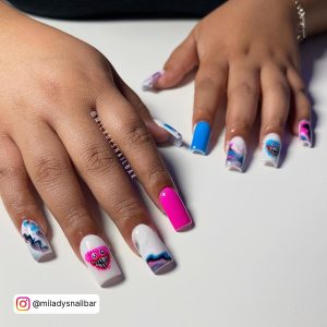 Spooky Blue, Pink, And White Acrylic Nails Design Over White Surface
