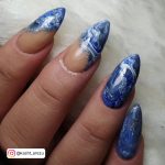 Stiletto Blue And White Marble Nails With Marble French Tips Over A Marble Surface