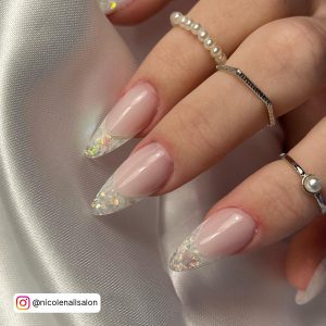 Stiletto-Shaped Ombre White Glitter Nails With Sparkling French Tips Over A Silk Cloth