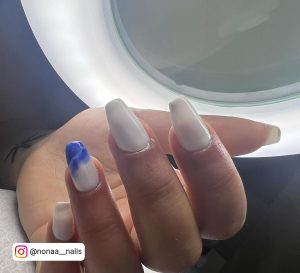 Stunning White Nails With Blue Marble Design And Ringlight In Background