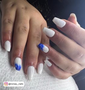 Stunning White Nails With Blue Marble Design On White Napkin
