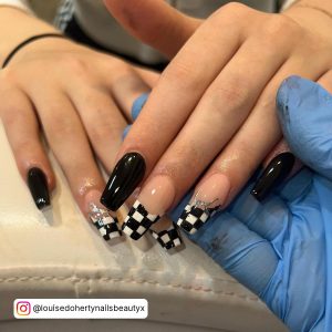 Technician Holding Fingers With Plain Black And Black And White French Nail Design With Check Tips.