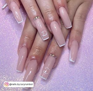 Thin White Tip Acrylic Nails With Rhinestones Over Pink Glittery Surface