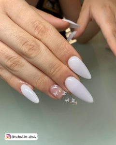 White Almond Nails With One Clear Almond Nail With Small White Butterflies