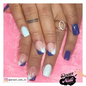 White And Blue French Tip Nails With Plain White And Blue Design Laying On Pink Fur