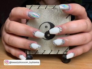 White Chrome Nails With Diamonds Holding A Decoration Piece