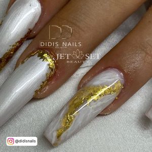White Glossy Coffin Nails With Gold Foil Against A White Background