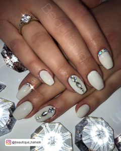 White Nails With Diamonds On Ring Finger And Index Finger