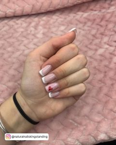 White Tip Nail Design With Red Heart Art On Pink Surface