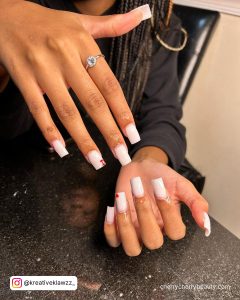 All White Nails With Rhinestones On A Marble Surface