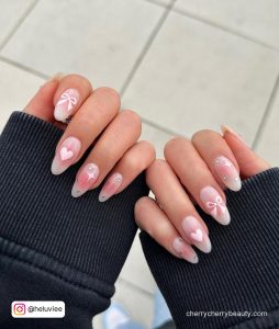 Almond Shape Pink And White Valentine Nails With Stencil Effect And Bow And Heart Designs