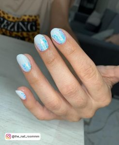 Glittery Blue And White Summer Nails Over Wooden Surface