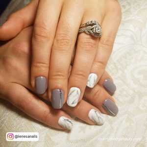 Gray And White Marble Nails With A Ring In One Finger
