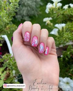 Hot Pink Nails With Silver Glitter In Front Of Plants