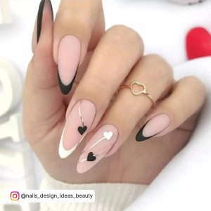 Long Almond Shape Nude Nails With Black And White French Tips And Black And White Heart Designs