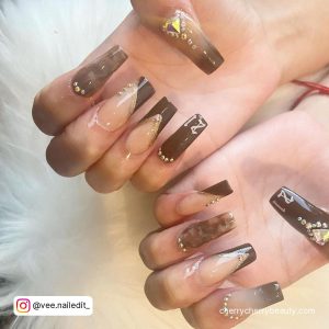 Long Coffin Shape Nude And Brown Nails With Ombre Effect, Diagonal Tips, French Tips, Cuticle Gems, Gold Rhinestones And 21 Written On The Tip