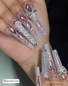 Long Grey Coffin Nails With Silver Glitter, Light Pink Rhinestones And Silver Capricorn Writing