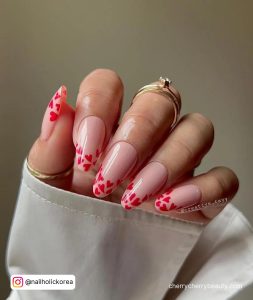 Long Round Tip Nude Nails With Red Hearts In The Tips