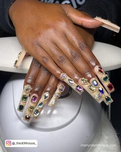 Long Square Tip Gold Glitter Nails With Colorful Rhinestones In A Line Up Each Nails