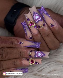 Long Square Tip Nude And Purple Glitter French Tip Nails With Heart Designs And Gems