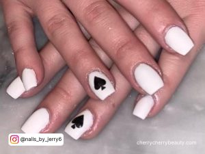 Matte Black And White Acrylic Nails With Spade Design On Ring Finger
