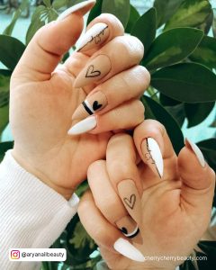 Matte Black And White Stiletto Nails In Front Of Plants