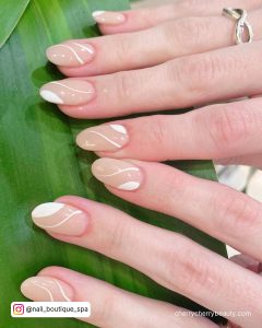 Nails With White Swirls On A Green Leaf