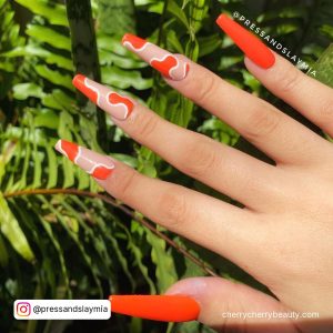 Orange White Marble Nails Infront Of Plants