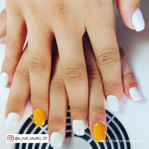 Orange Yellow And White Nails On A Nail Dryer