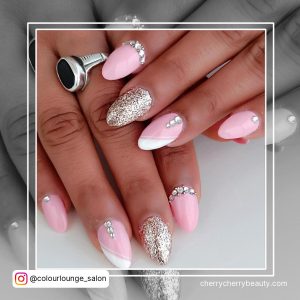 Pink And White Nails With Rhinestones And Glitter On One Finger
