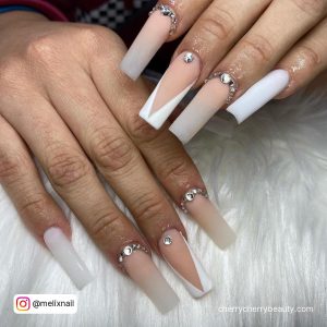 Pink And White Ombre Coffin Nails With Rhinestones On A White Surface