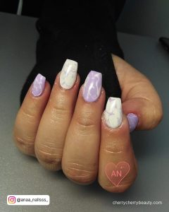 Purple And White Marble Nails Holding A Black Piece