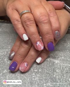 Purple Nails With White Flowers On One Finger