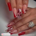 Red, Clear And Nude Acrylic Square Tip Long Nails With Red Diagonal Tip Design And Glitter Design
